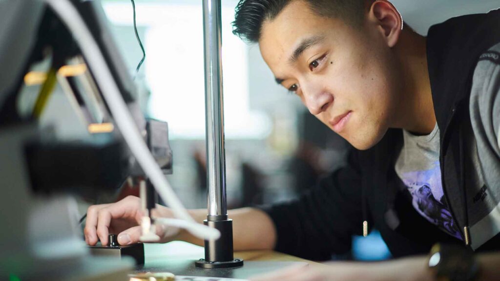 A student working with a robot in the Robotics lab.