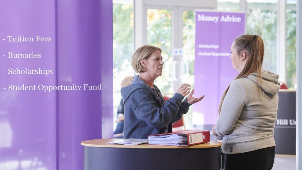mature female student at the money advice stand getting support for female member of staff