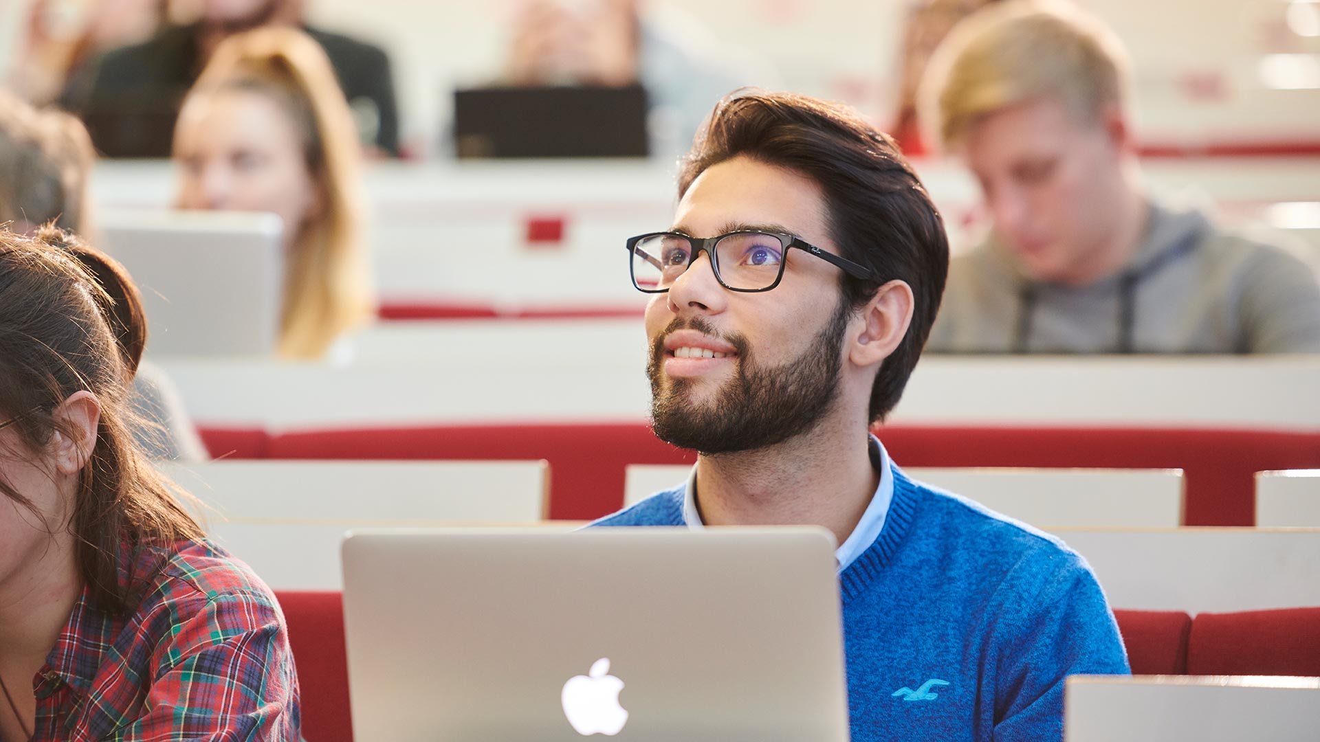 Image of student sitting in lecture theatre with their laptop
