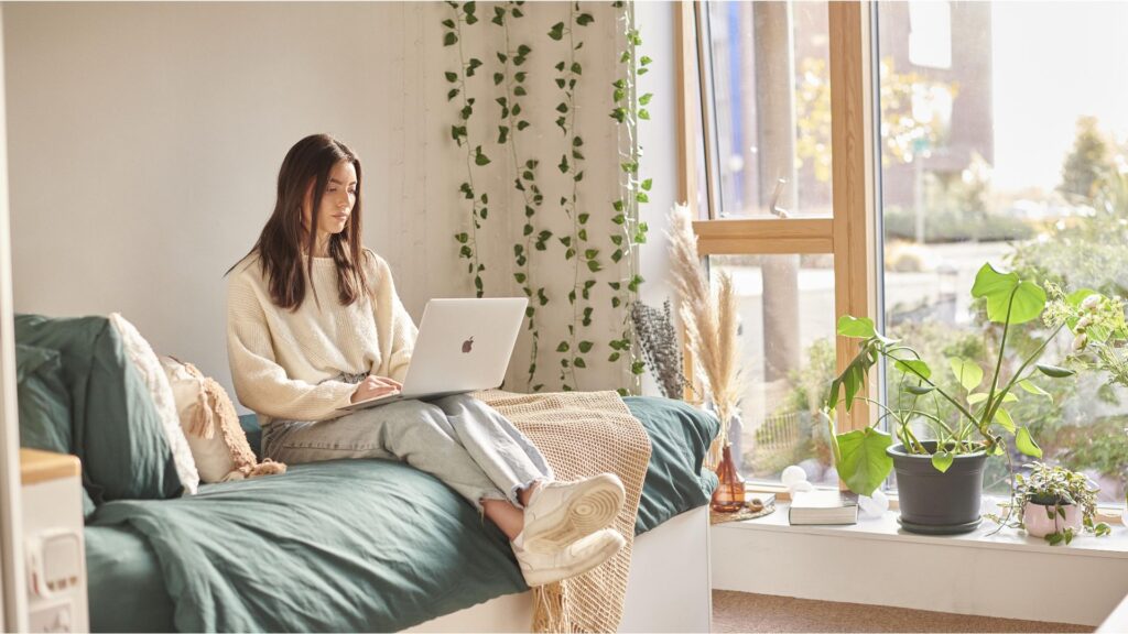 female student in halls on laptop