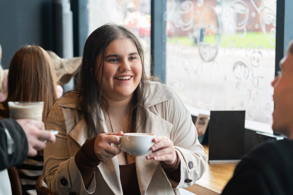 Student drinking coffee in cafe in Ormskirk