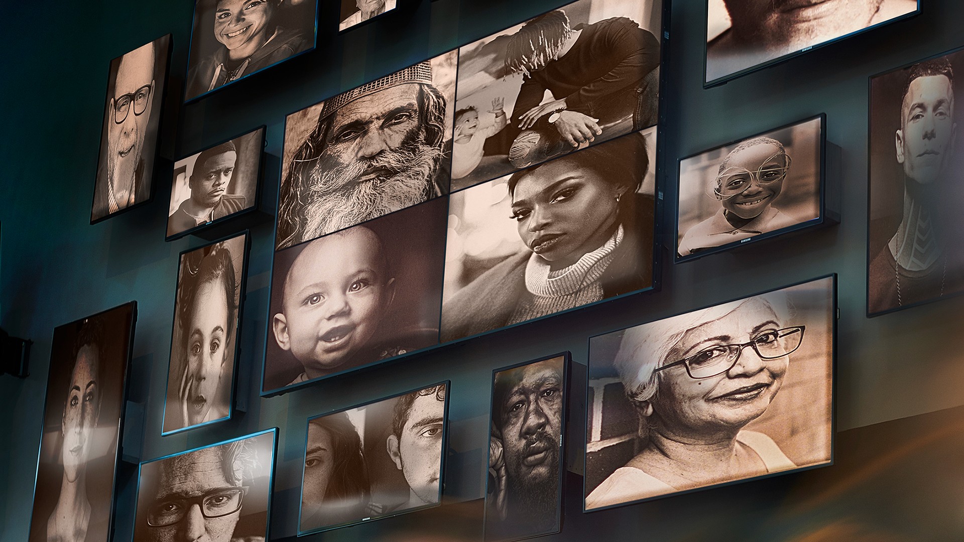 Bank of screens featuring a variety of people's faces.